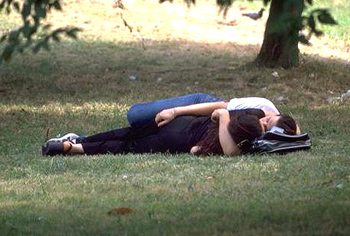 Pareja besandose sobre la hierba